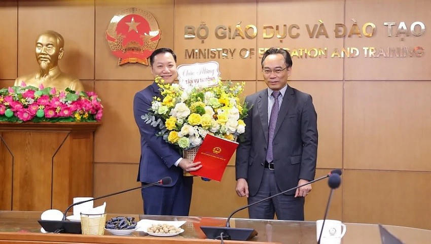 Thứ trưởng Bộ GD&ĐT Hoàng Minh Sơn (bên phải) trao Quyết định và tặng hoa chúc mừng tân Vụ trưởng Vụ Giáo dục đại học Nguyễn Tiến Thảo. (Ảnh: Bộ GD&ĐT)
