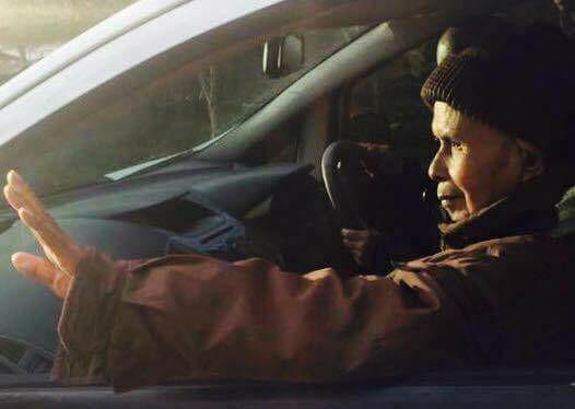 Thiền sư Nhất Hạnh vẫy tay chào mọi người trên xe.