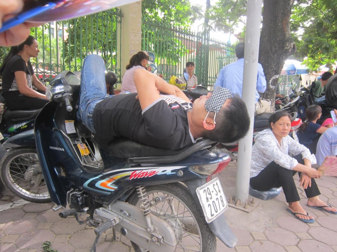 Trong khi đó, trong lúc chờ đợi thì nhiều người leo lên xe máy ngủ một giấc.