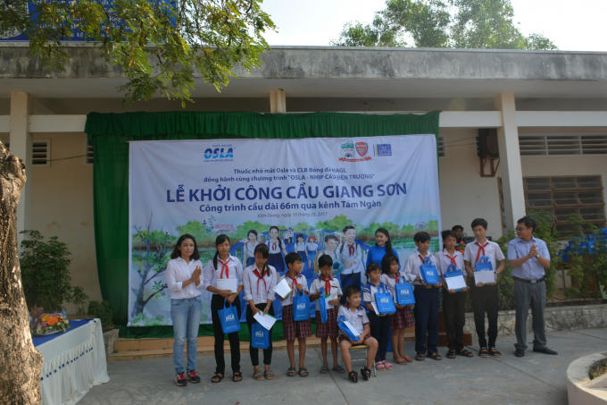 Đại diện Thuốc nhỏ mắt Osla trao tặng học bổng cho các em học sinh trường THCS Thuận Tiến. Ảnh Quốc Bảo