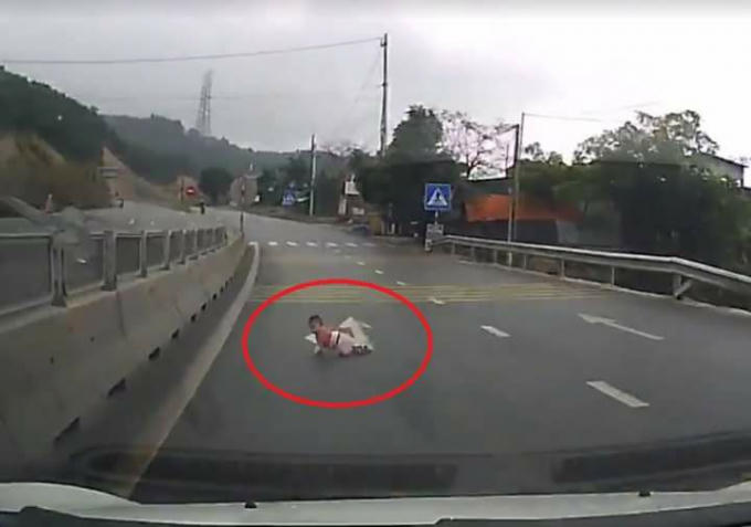 Em bé bò ra giữa đường. Ảnh: Cắt từ clip.
