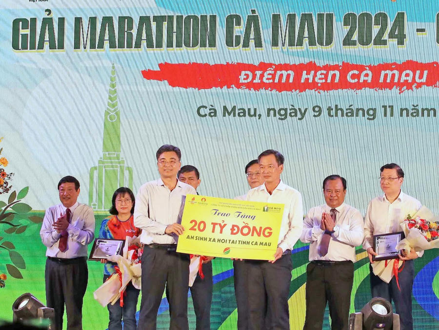 Đại diện Công ty Cổ phần phân bón dầu khí Cà Mau (bên trái) trao tặng bảng tượng trưng hỗ trợ an sinh xã hội 20 tỉ đồng cho tỉnh Cà Mau.