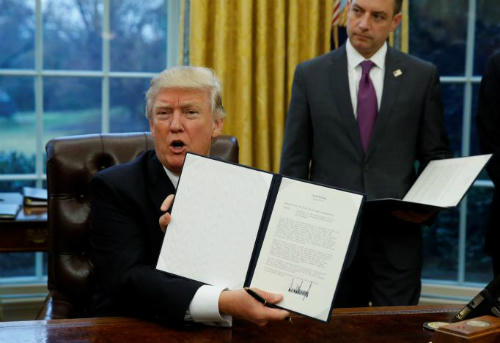 Ông Donald Trump nâng cao tờ lệnh ngay sau khi ký và gọi đây là điều tốt đẹp dành cho người lao động Mỹ. Ảnh: Reuters.
