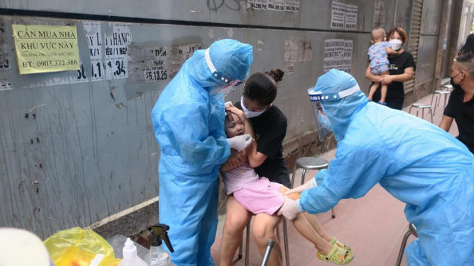 Lực lượng chức năng tổ chức lấy mẫu xét nghiệm tại khu dân cư nhà cháu bé dương tính COVID-19 được đón từ TP HCM về