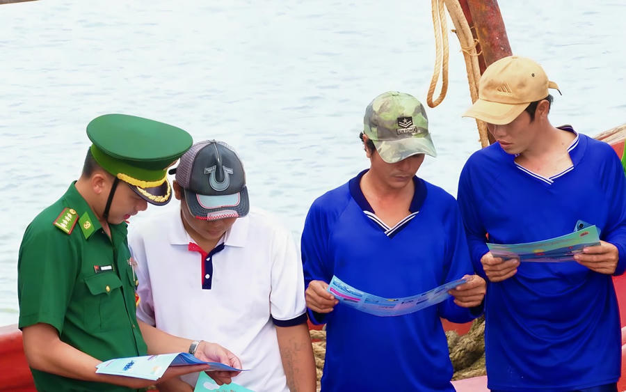 Phát tờ rơi tuyên truyền pháp luật, vận động ngư dân thực hiện tốt quy định chống khai thác IUU.