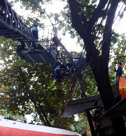 Lực lượng chức năng tiến hànhh đưa thanh niên xuống đất.