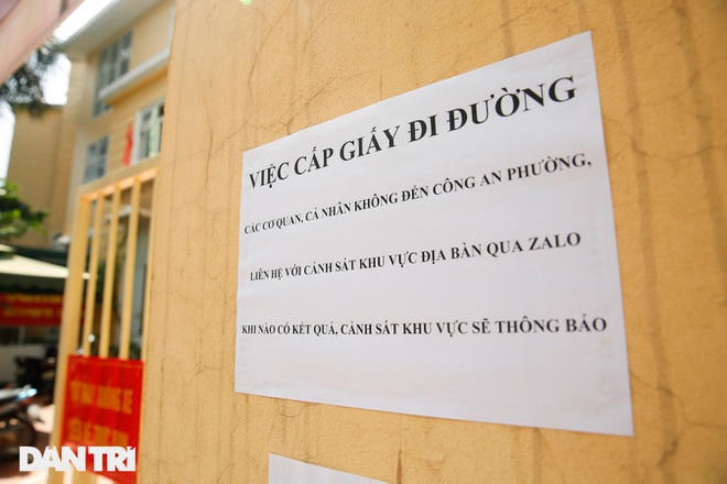 Tại trụ sở Công an phường Dịch Vọng Hậu, lực lượng chức năng dán thông báo về việc cấp giấy đi đường phía trước cổng.