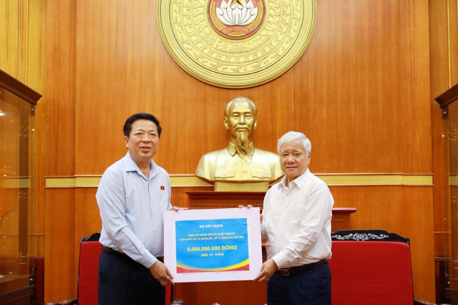 Thay mặt Bộ Xây dựng, Bộ trưởng Trần Hồng Minh trao số tiền 5 tỷ đồng ủng hộ đồng bào bị thiệt hại do cơn bão số 10, số 11 gây ra. (Ảnh: Bộ Xây dựng)