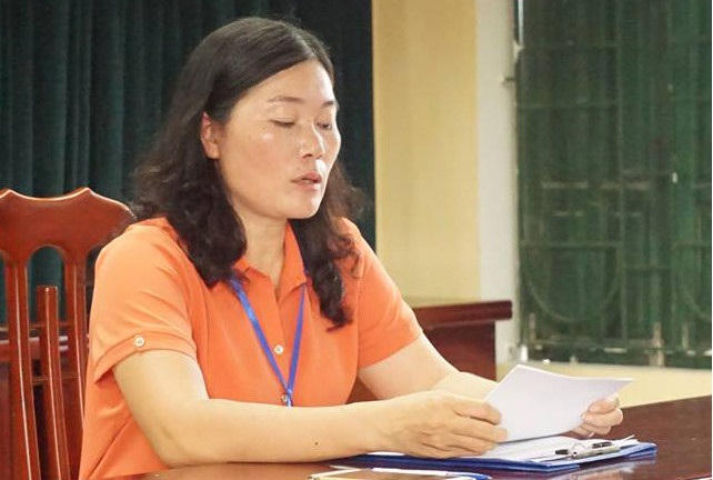 Bà Nguyễn Kim Oanh, Hiệu trưởng Trường Tiểu học Sơn Đồng ngồi im trong phòng họp bất chấp phụ huynh la hét bên ngoài.