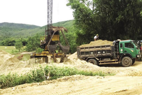 Một điểm tập kết cát sạn trái phép trên QL12A đoạn qua xã Cảnh Hóa. Ảnh: Lê Phi Long