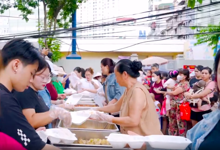 Các thành viên của G2G Foundation trao từng xuất cơm đến mọi người.