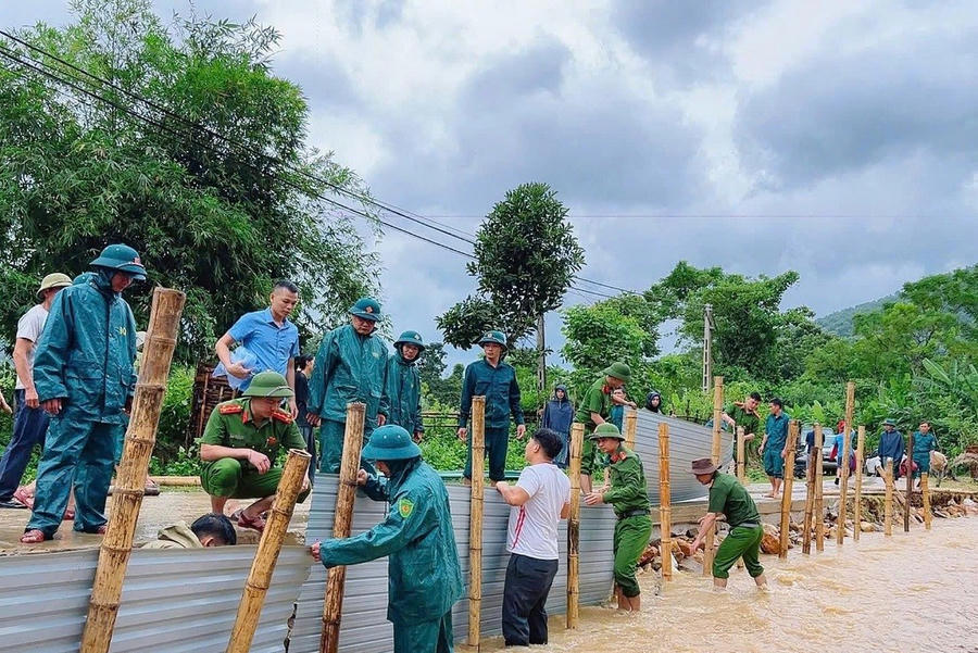 Do ảnh hưởng của bão số 10 gây ra mưa to làm xói lở đoạn đường vào bản, lực lượng Công an xã phối hợp chính quyền và nhân dân khắc phục tuyến đường để việc đi lại được thuận lợi. (Ảnh: Bộ Công an)