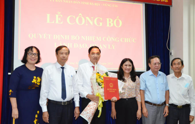 Ông Nguyễn Văn Thọ, Chủ tịch UBND tỉnh trao quyết định và tặng hoa chúc mừng ông Trần Quốc Khánh