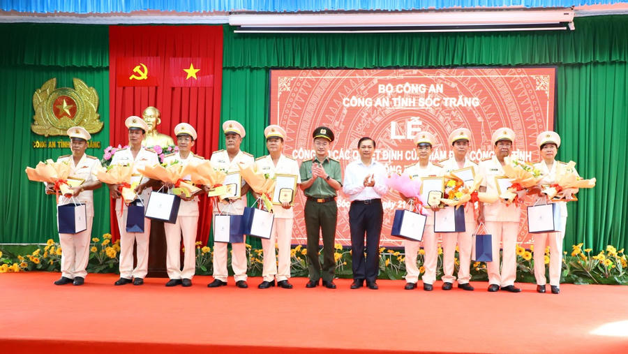 Ông Trần Văn Lâu, Phó Bí thư Tỉnh ủy, Chủ tịch UBND tỉnh và Đại tá Trần Văn Dương, Bí thư Đảng ủy, Giám đốc Công an tỉnh trao quyết định và tặng hoa cho các đồng chí nghỉ công tác hưởng chế độ hưu trí. Ảnh: Minh Tấn