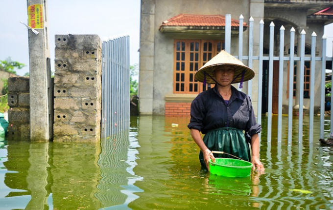 Cô Nguyễn Thị Mùi đứng trước ngôi nhà đã ngập ngót 10 ngày. Cô Mùi cho biết, so với những ngày trước thì nước đã rút đi khoảng 30-40cm. Hiện toàn bộ khu vực thôn Nam Hài đều đang thiếu nước sạch, người dân phải mua nước bình 20L về để dùng nhưng không đủ so với nhu cầu dù là tối thiểu.