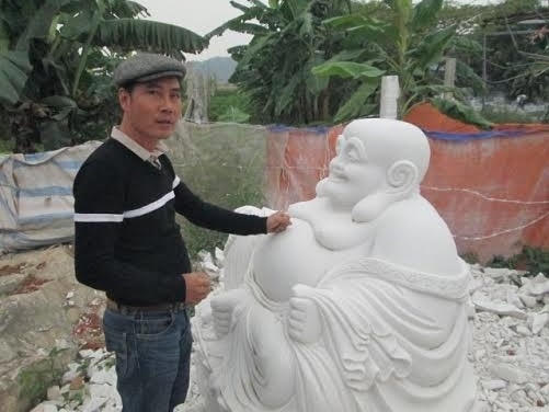 Anh Trọng bên một tác phẩm điêu khắc đá của mình.