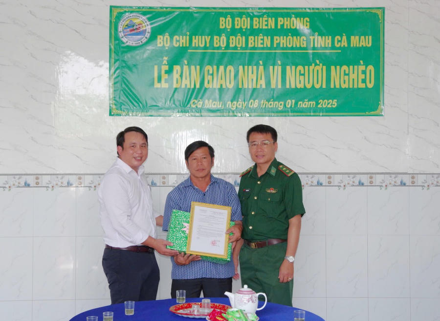 Trung tá Võ Minh Đương - Phó Chủ nhiệm Chính trị BĐBP tỉnh Cà Mau và lãnh đạo địa phương trao Quyết định của BĐBP tỉnh tặng nhà và tặng quà cho ông Trần Văn Hiểm.