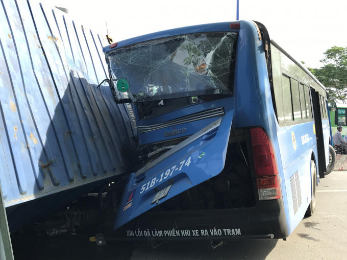 Thùng container lật đè trúng xe buýt.