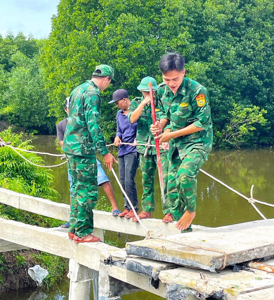 Cán bộ, chiến sĩ Đồn Biên phòng Tam Giang Tây gia cố phần móng cầu.