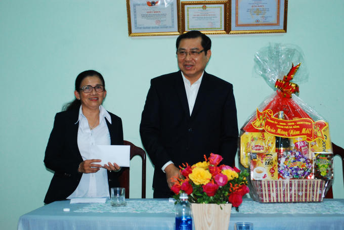 Lãnh đạo Trung tâm nuôi trẻ mồ côi (trái) nhận quà động viên của lãnh đạo thành phố.