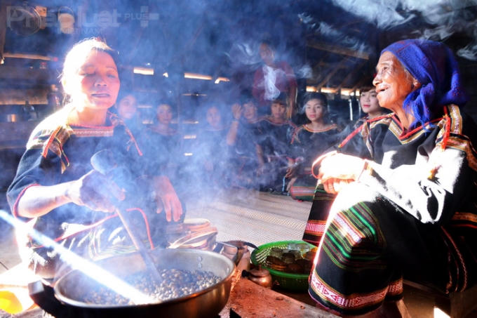 Mí Yă Bě và Amí Choan rang cà phê trên bếp củi. (Ảnh: Đoàn Bắc)