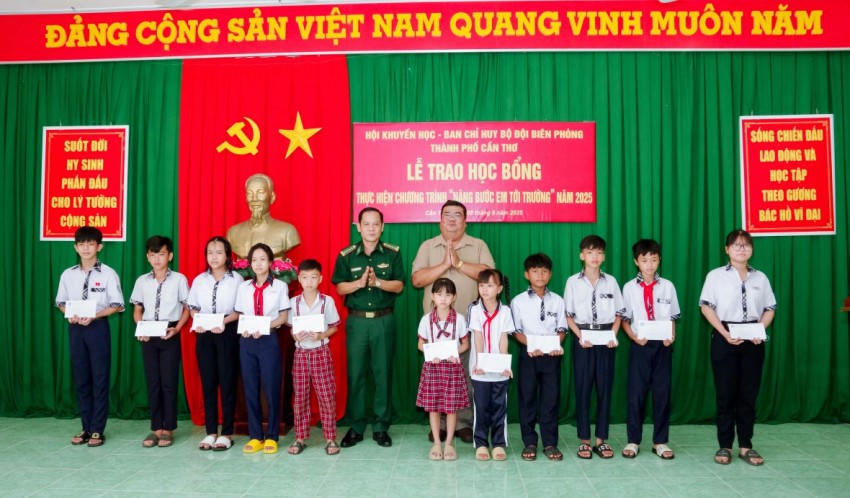 Đại tá Huỳnh Thanh Hùng và ông Lâm Sao trao học bổng cho các em học sinh. Ảnh: Văn Long