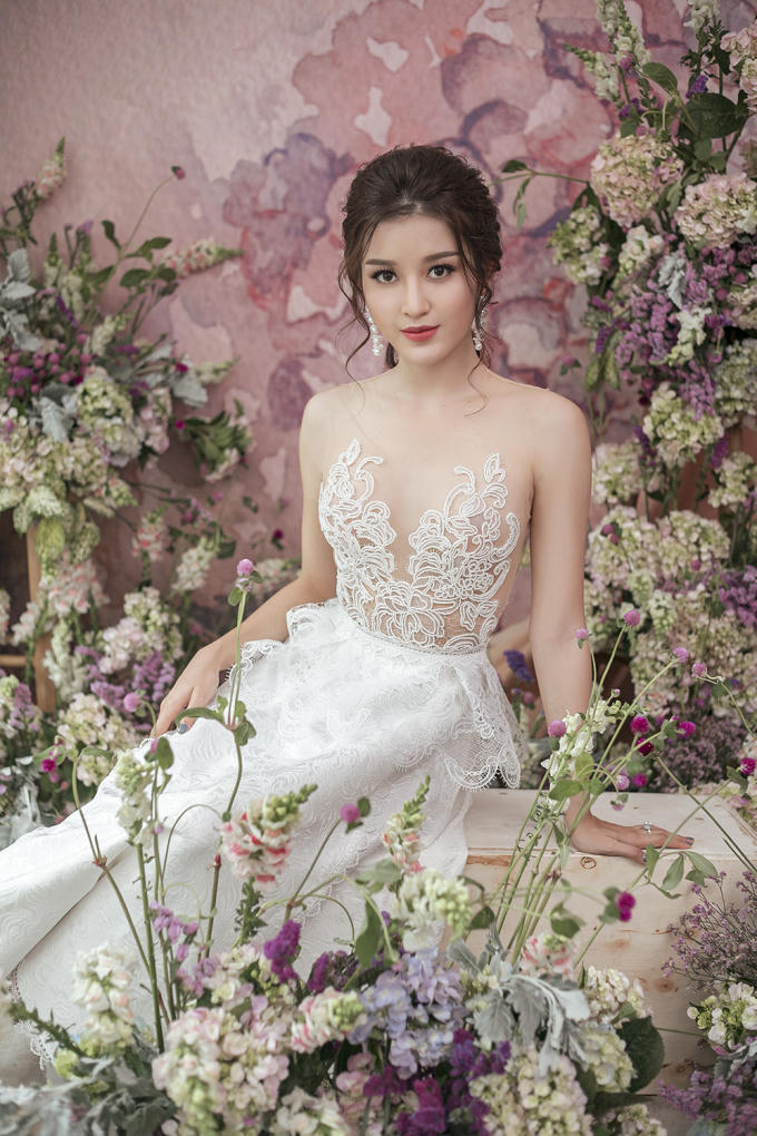 Phom dáng cúp ngực kết hợp đắp ren thủ công giúp tôn lên vai trần gợi cảm, làn da trắng ngần của Huyền My. Với sắc trắng dịu dàng của chiếc váy, các cô gái chỉ cần sử dụng tông trắng điểm nhẹ nhàng, son môi cam tươi tắn để hoàn thiện ngoại hình xinh đẹp của mình.