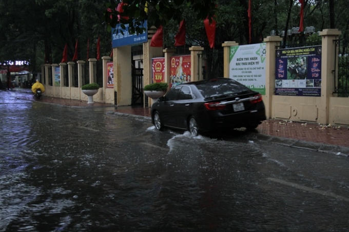 Ngay cả ô tô chủ phương tiện cũng lái xe một phần lên vỉa hè để tránh nước ngập.
