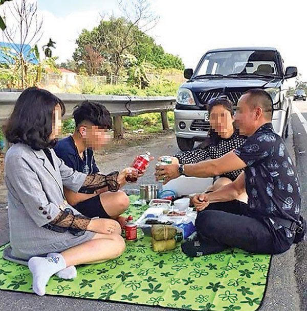 Một gia đình vô tư ăn uống trên làn dừng khẩn cấp cao tốc Nội Bài - Lào Cai (chiều 15/2).