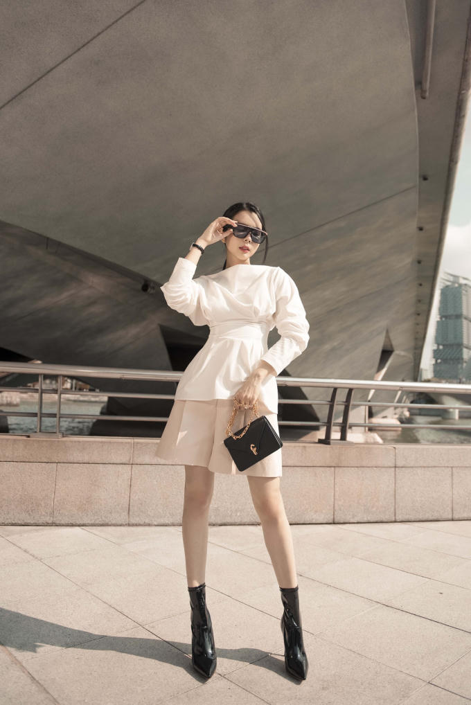 Trong set đồ này, cô tinh tế kết hợp một chiếc áo kiểu cách với phần bóp nhẹ ở eo cùng lớp bèo dúm nơi cổ tay kết hợp cùng chiếc quần đùi ống rộng có chút gì đó nữ tính và phóng khoáng.