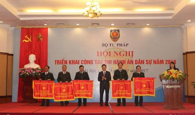 Bộ trưởng Lê Thành Long trao Cờ Chính phủ cho các đơn vị có thành tích xuất sắc tại Hội nghị triển khai công tác THADS 2018.