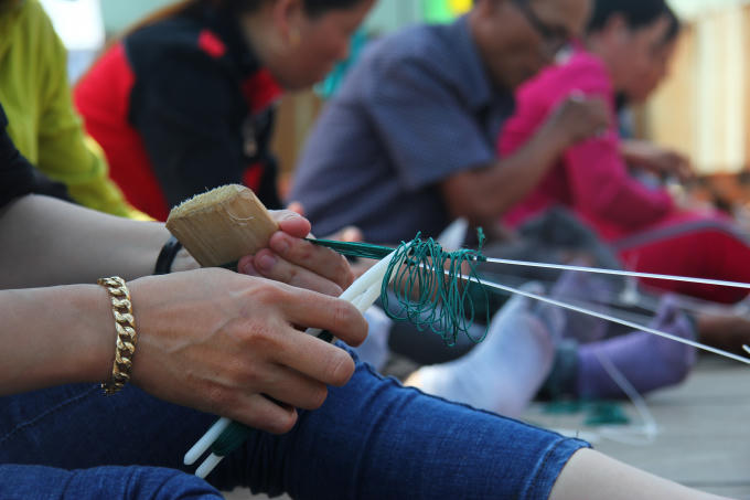 Những người ngư dân đang khéo léo thể hiện phần thi đan lưới của mình. (Ảnh: Vân Trương)