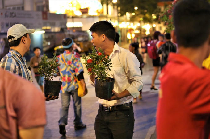 Hai thanh niên này cũng rất yêu hoa, cố gắng thu nhặt những chậu còn tươi. Ảnh: Trường Sơn