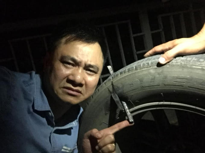 Biểu cảm của NSND Tự Long khi chiếc lốp xe ô tô của anh bị thanh sắt đâm xuyên.