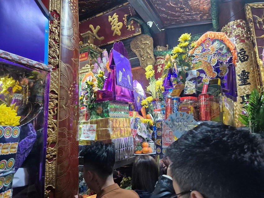 Dòng người ken đặc từ ngoài vào trong khiến cho hàng nghìn du khách phải chen nhau đội lễ lên đầu mới vào được chánh điện để xin lộc cầu tài.