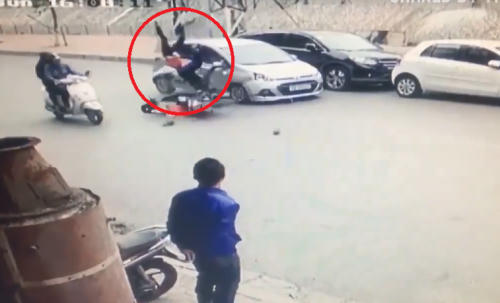 Ôtô chạy lấn làn đâm hai người đi xe máy bay lên không trung rồi ngã văng xuống đường. Ảnh: Cắt từ Clip.