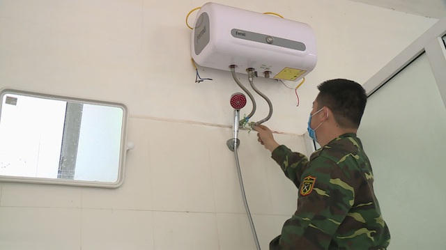 Chiến sĩ quân đội tiến hành lắp đặt hệ thống điện, nước phục vụ sinh hoạt cho công dân về cách ly tại trường (Ảnh: Trọng Lộc).