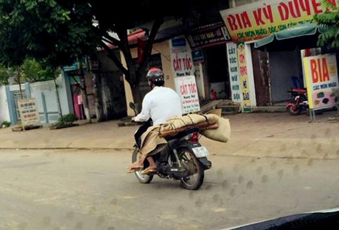 Do không có tiền thuê xe ô tô nên gia đình chị P. đã nhờ người quen sử dụng xe máy chở thi thể về mai táng. Ảnh: Facebook Tùng Hải.