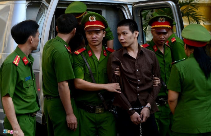 Các bị cáo mặc áo nâu, tay bị còng, trắng và có vẻ tăng cân so với phiên xử sơ thẩm. Sau đó cả 3 được công an di chuyển lên phòng xử án.