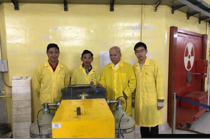 Giáo sư Phạm Duy Hiển bên nhóm nghiên cứu khai thác kênh ngang số ba trên lò phản ứng hạt nhân Đà Lạt. Nguồn: VINATOM.