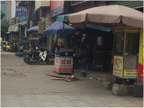 Một gia đình trên đường Tố Hữu đốt lửa trước cửa nhà.