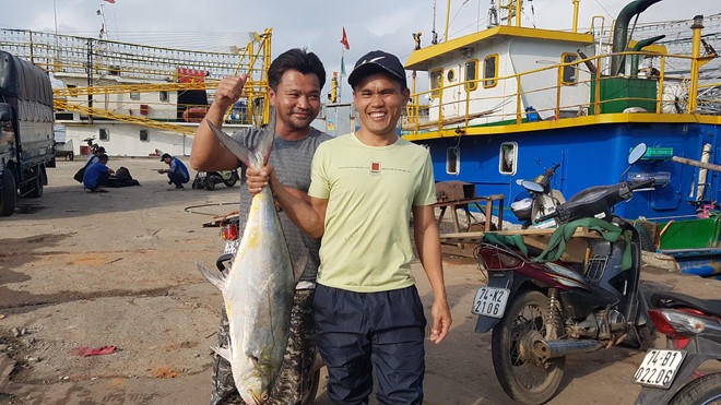 Ngư dân Lê Văn Viện (bìa trái) tại cảng cá nam Cửa Việt sáng 12.2.