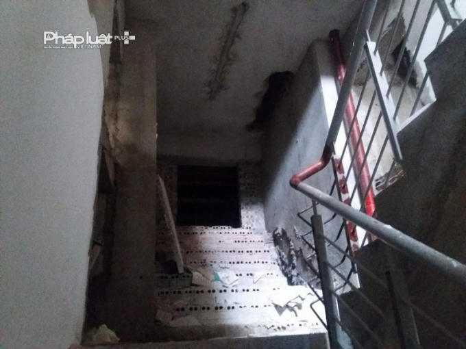 Lối thoát hiểm, các bậc thang chưa được trát vữa và lắp đặt thiết bị.              Vật liệu tập kết trước cửa phòng.