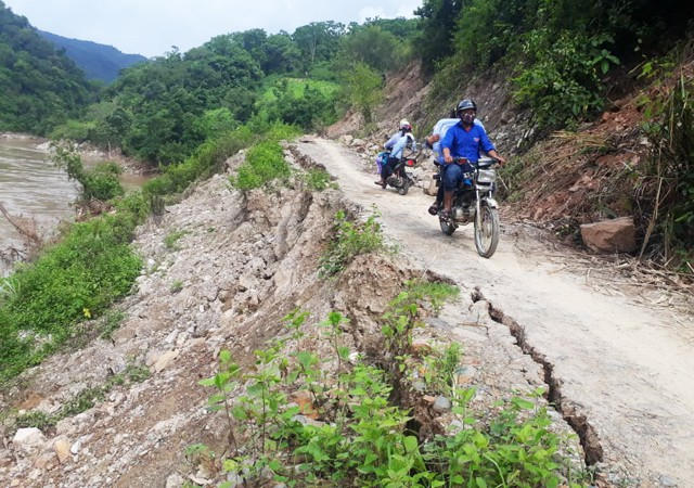 Người dân di chuyển chênh vênh trên con đường đang bị sông "bóc" đến tim đường