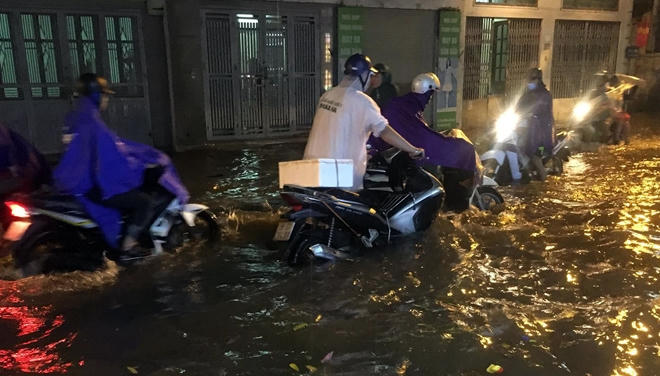 Mưa lớn khiến nhiều xe máy bị chết máy khiến chủ xe phải dắt bộ.