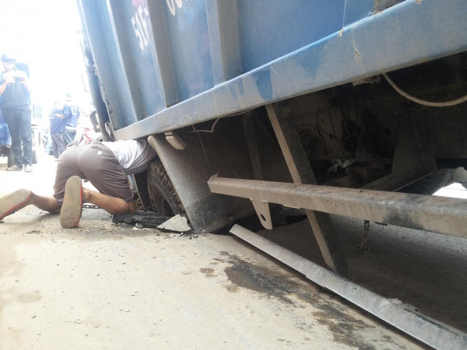 Bánh sau của chiếc xe rác sụp vào hố tử thần.