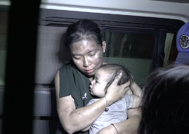 Người mẹ ôm chầm đứa con sau khi được đưa xuống đất an toàn.