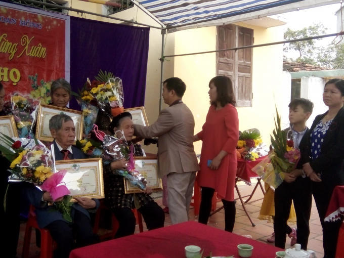 Con cháu vui vẻ, phấn khởi tặng hoa chúc mừng ông bà, cha mẹ.
