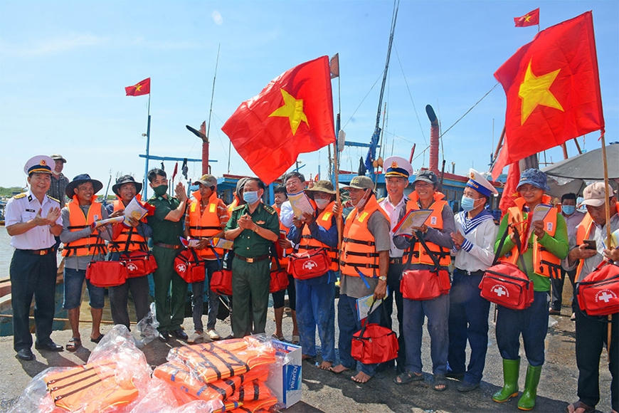 Chiến sỹ vùng 2 Hải quân tặng cờ, áo phao và túi thuốc cấp cứu cho ngư dân.