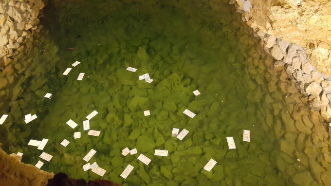 Nhiều du khách vẫn thả tiền lẻ vào giếng nước bên trong động.